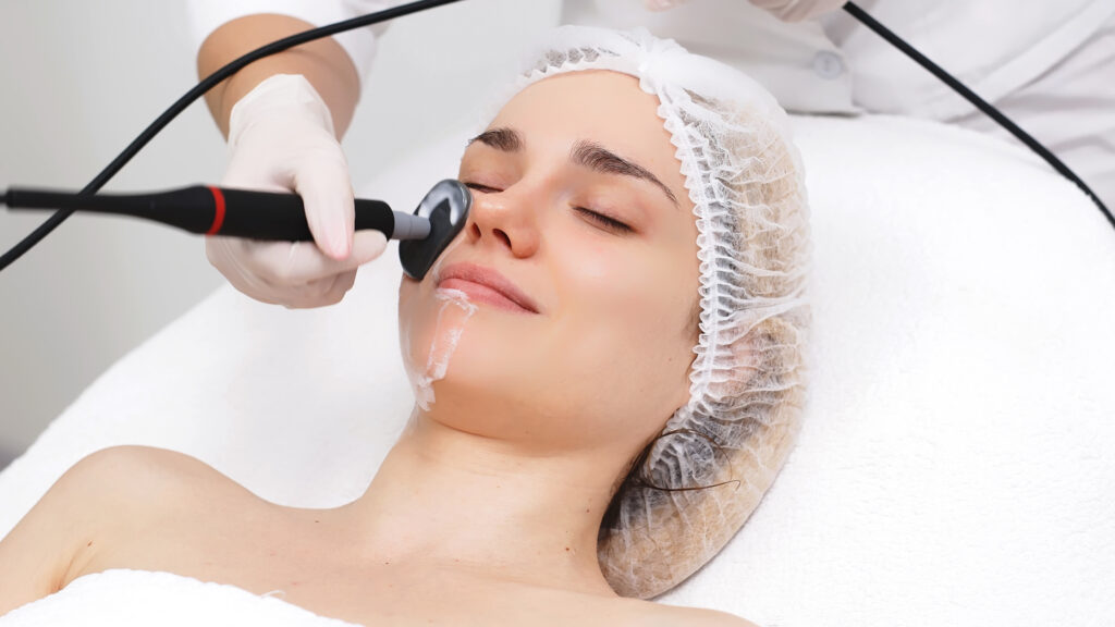 Frau bei professioneller Gesichtsbehandlung mit dermatologischem Geraet – Aesthetico als begleitende Pflege bei sensibler Haut
